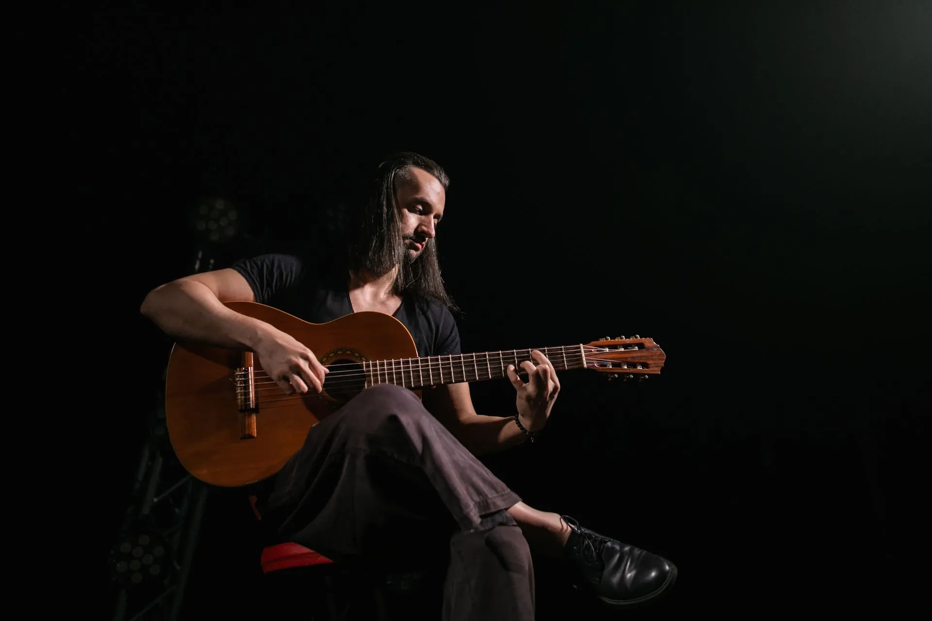 Fado singer performing beside a Portuguese guitarist in a candlelit stone-walled room in Lisbon