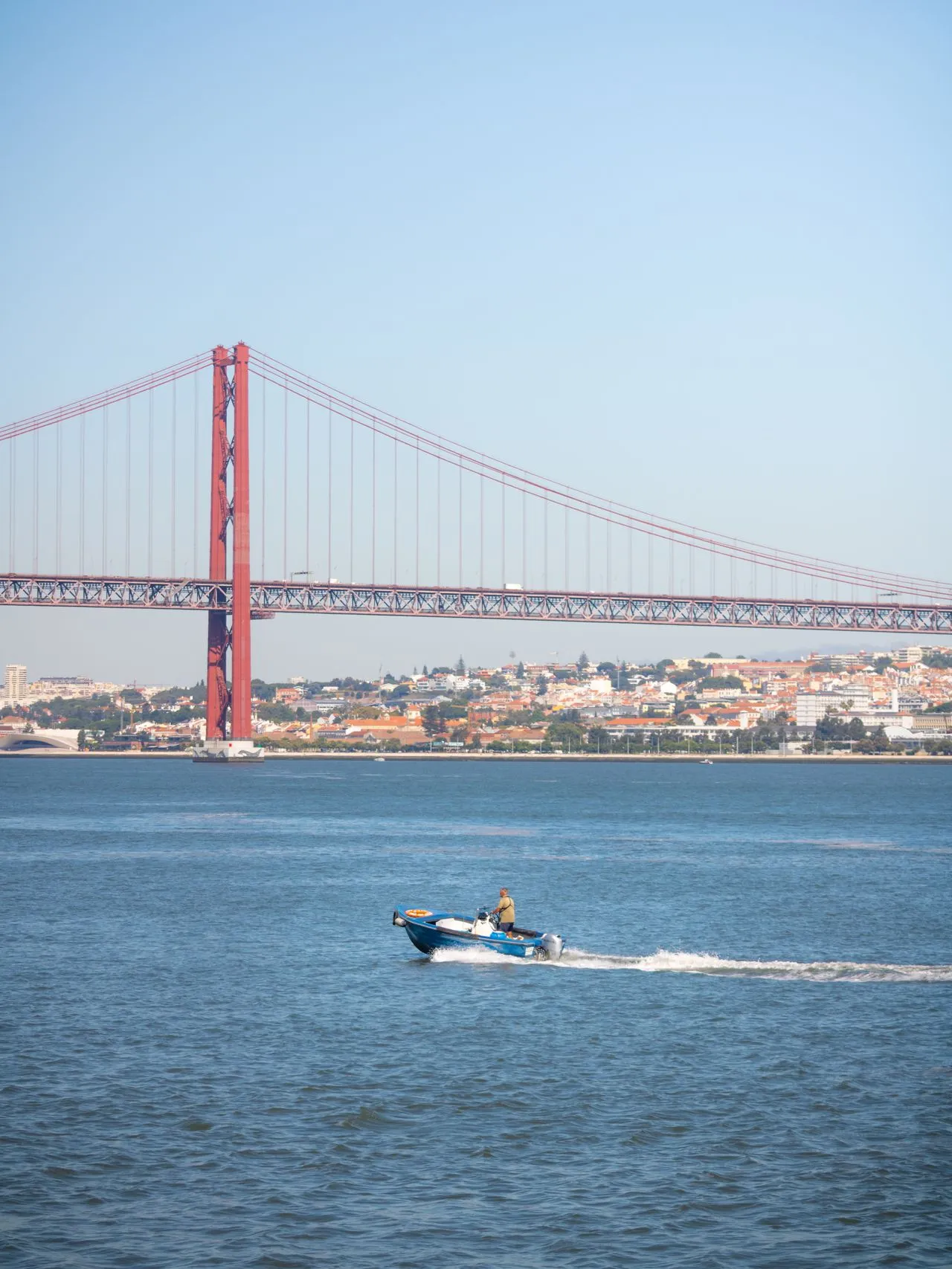 The Ponte 25 de Abril suspension bridge over the Tagus river seen from a boat in Lisbon