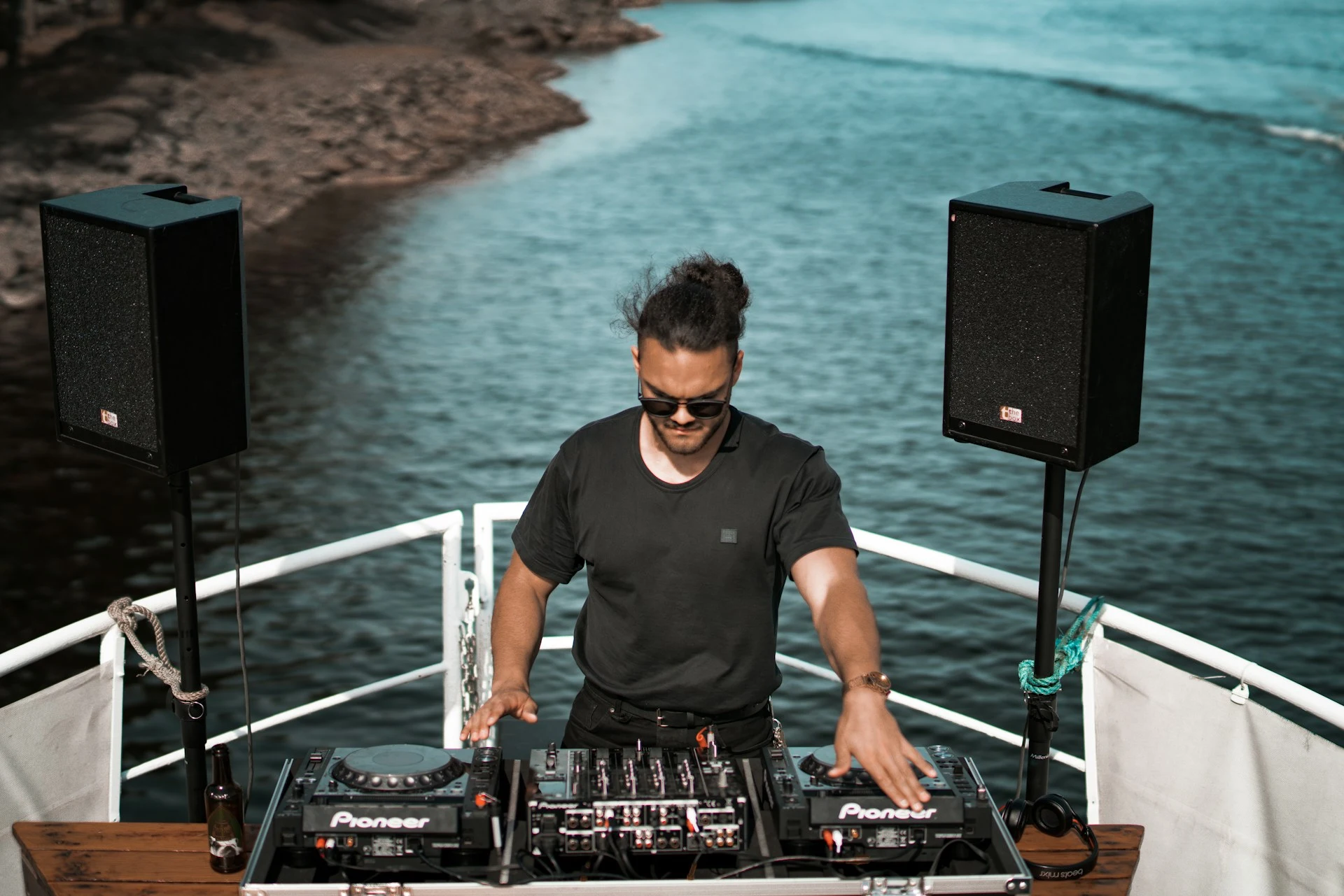 DJ playing to a crowd on the deck of a party boat cruise in Portugal