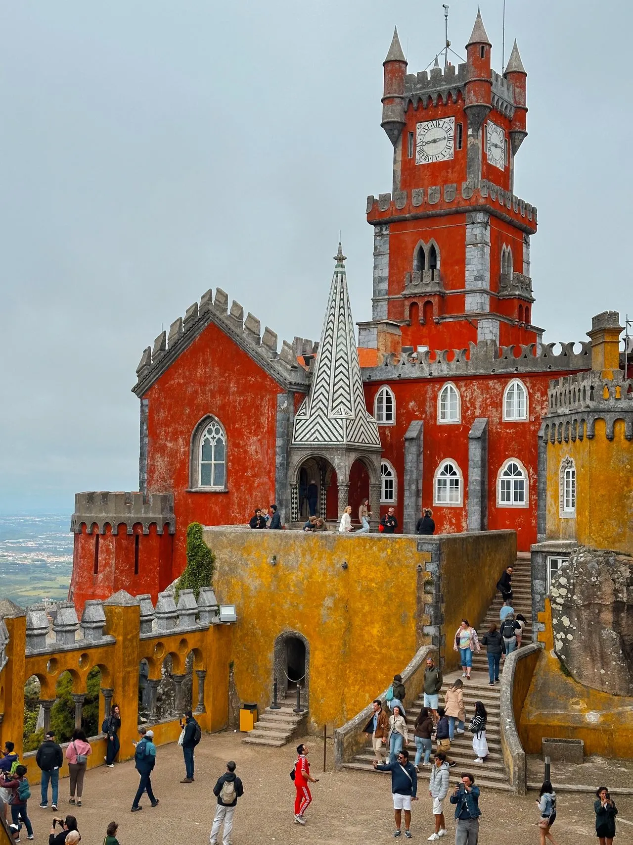 The red and yellow towers of Pena Palace rising above the wooded hills of Sintra