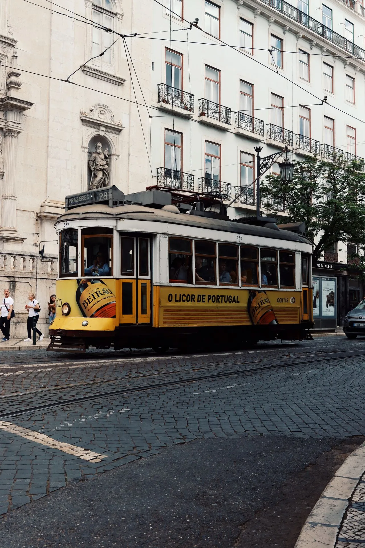 Classic yellow Remodelado tram on a narrow street in Lisbon, Portugal